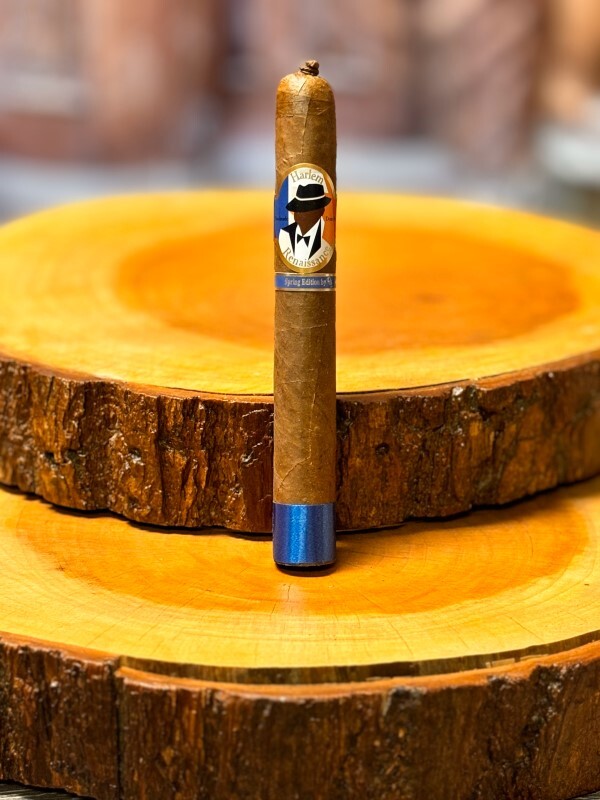 Harlem Renaissance African Cameroon Toro Spring Limited Edition cigar displayed on wooden ashtray with blue band detail.