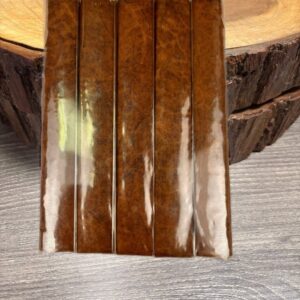 Five premium box-pressed Sumatra cigars with rich brown wrappers displayed on rustic wood surface