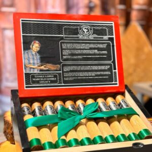Gomez Lopez Habano Legacy cigar box with red lid featuring portrait and green ribbon bow around premium cigars.