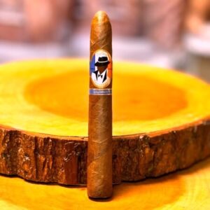 Premium cigar with branded band resting on yellow circular ashtray with blurred background