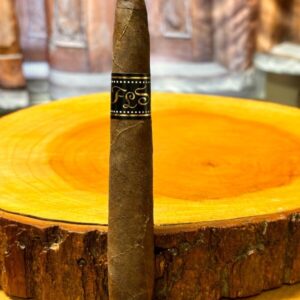 FLS Nicaragua cigar displayed on yellow wooden ashtray with blurred bottles in background