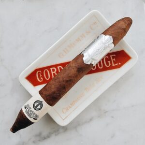 Premium Principle Aviator Escopette cigar with white band on marble surface in ceramic tray with red Cordoba label.