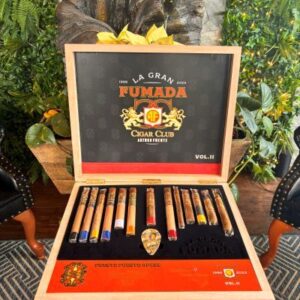 La Gran Fumada Impossible Collection Vol. II cigar box open displaying premium cigars with decorative skull emblem and tropical foliage backdrop.