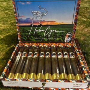 Harlem Renaissance Toro cigars box open displaying ten premium cigars with gold bands and dark wrappers in grass setting