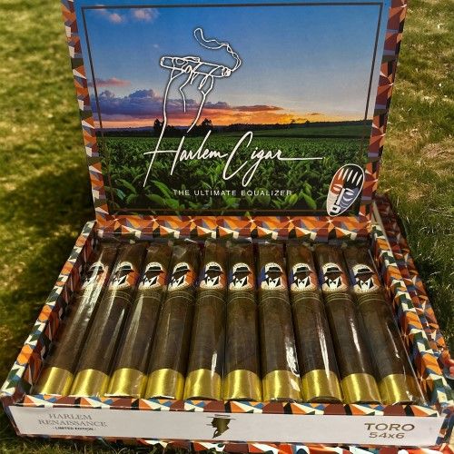 Harlem Renaissance Toro cigars box open displaying ten premium cigars with gold bands and dark wrappers in grass setting
